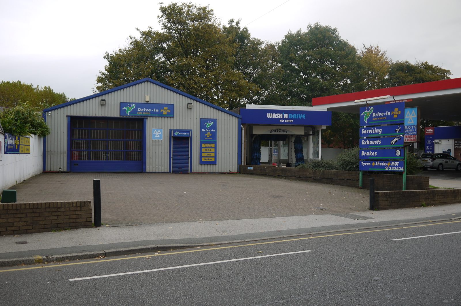 The original Drive-In PLUS frontage, with its blue sign board listing Servicing, Exhausts, Brakes, Tyres, Shocks and MOT