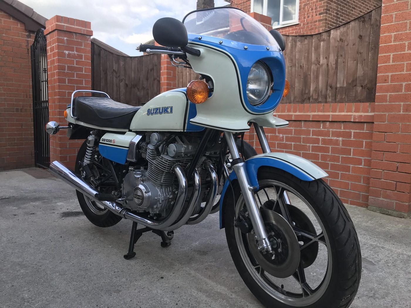 A blue and white classic Suzuki motorbike, photographed by a customer